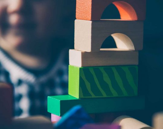 Kid playing with wooden blocks